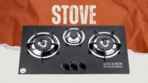 "Stainless steel kitchen stove with four burners and control knobs, illuminated by overhead lighting,