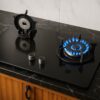 Glass top HOB, kitchen stove with two burners and control knobs, illuminated by overhead lighting,kitchen stove, electric stove, gas stove, gas hob,