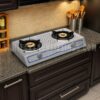 Electric Gas Stove,"Stainless steel kitchen stove with Double burner and control knobs, illuminated by overhead lighting,