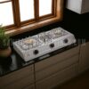 Gas Stove RINO RS111T,"Stainless steel kitchen stove with Double burner and control knobs, illuminated by overhead lighting,